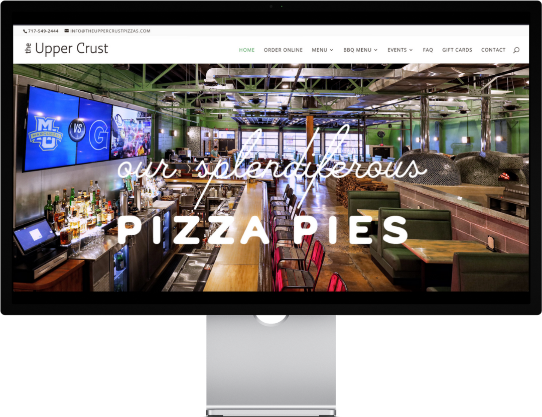 Restaurant interior with bar, green walls, and "our splendiferous pizza pies" text.