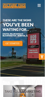 Digital billboard photo with advertising text, blue sky, and orange logo.